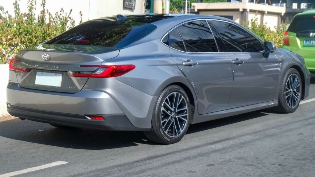 Current-generation (2026) Toyota Camry hybrid sedan in Precious Metal, front three-quarter view